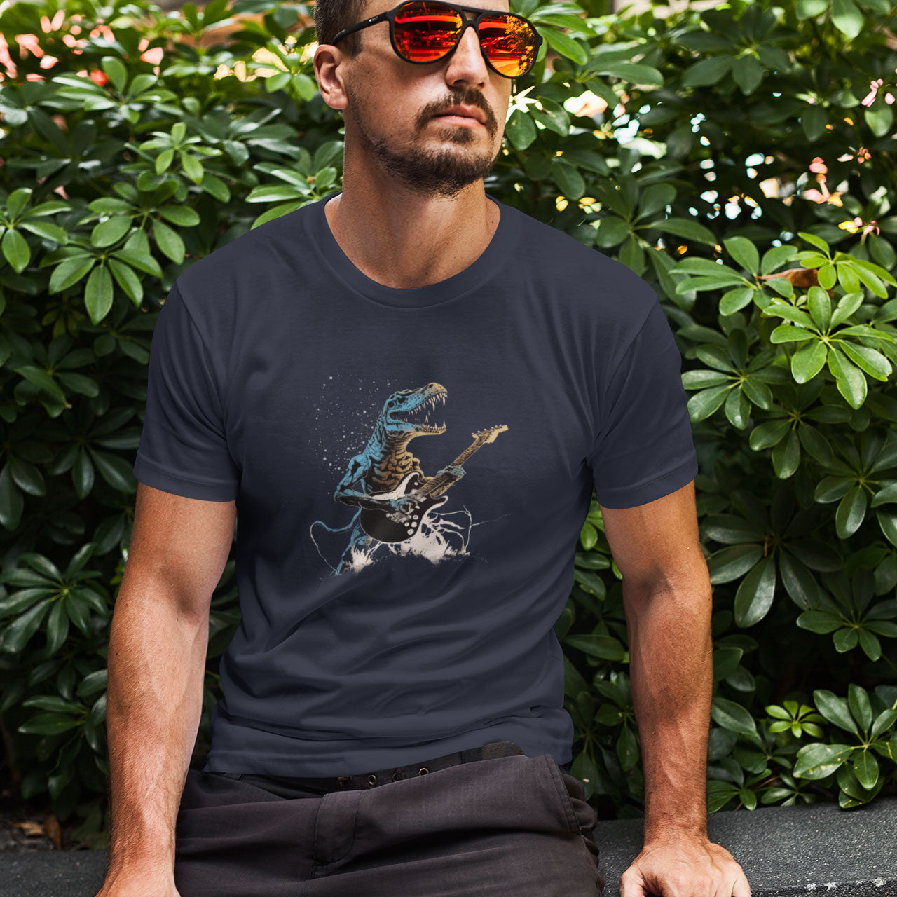 A guy wearing a dark grey t-shirt with a t-rex shredding out on a guitar print