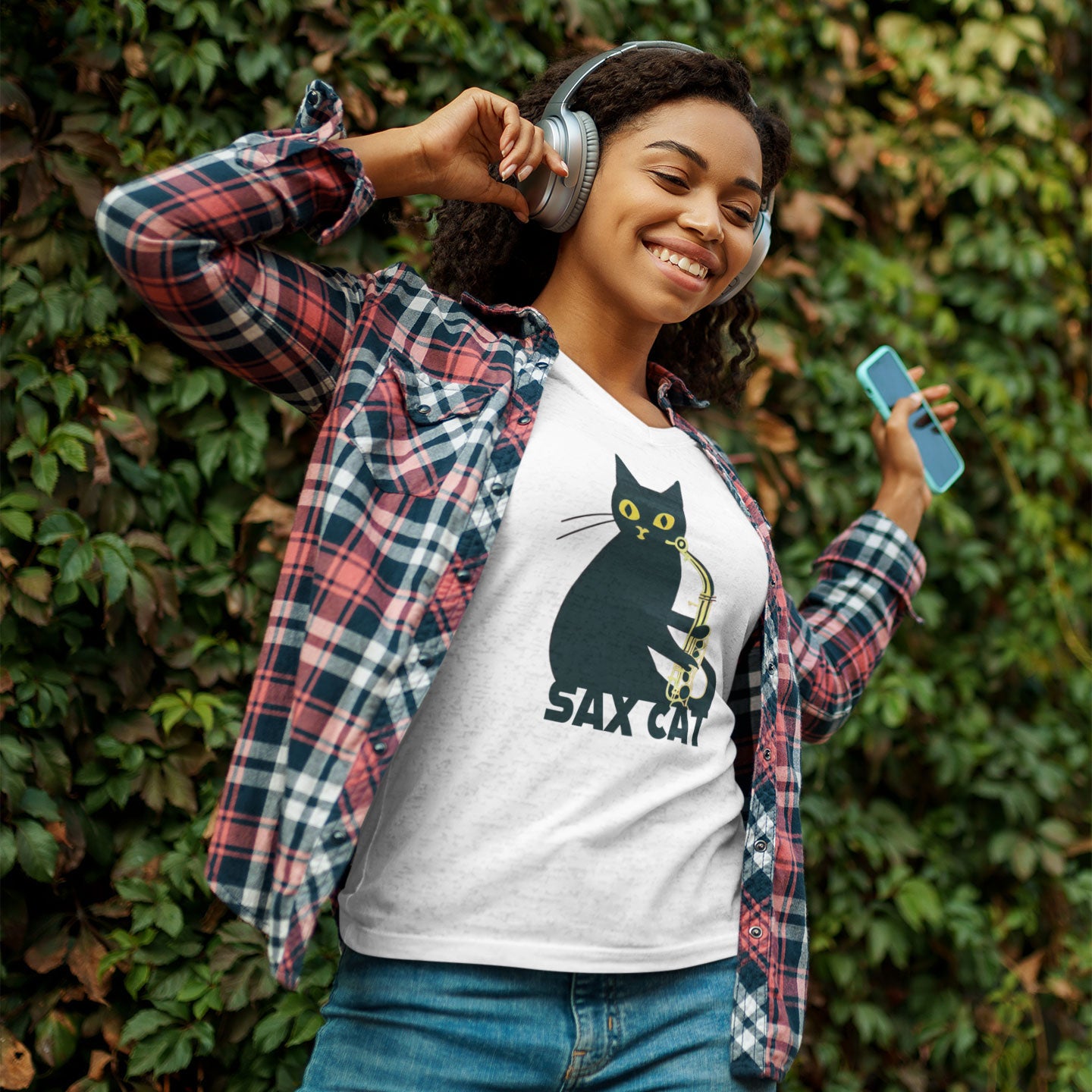 Girl listening to music wearing a white t-shirt with a sax cat print
