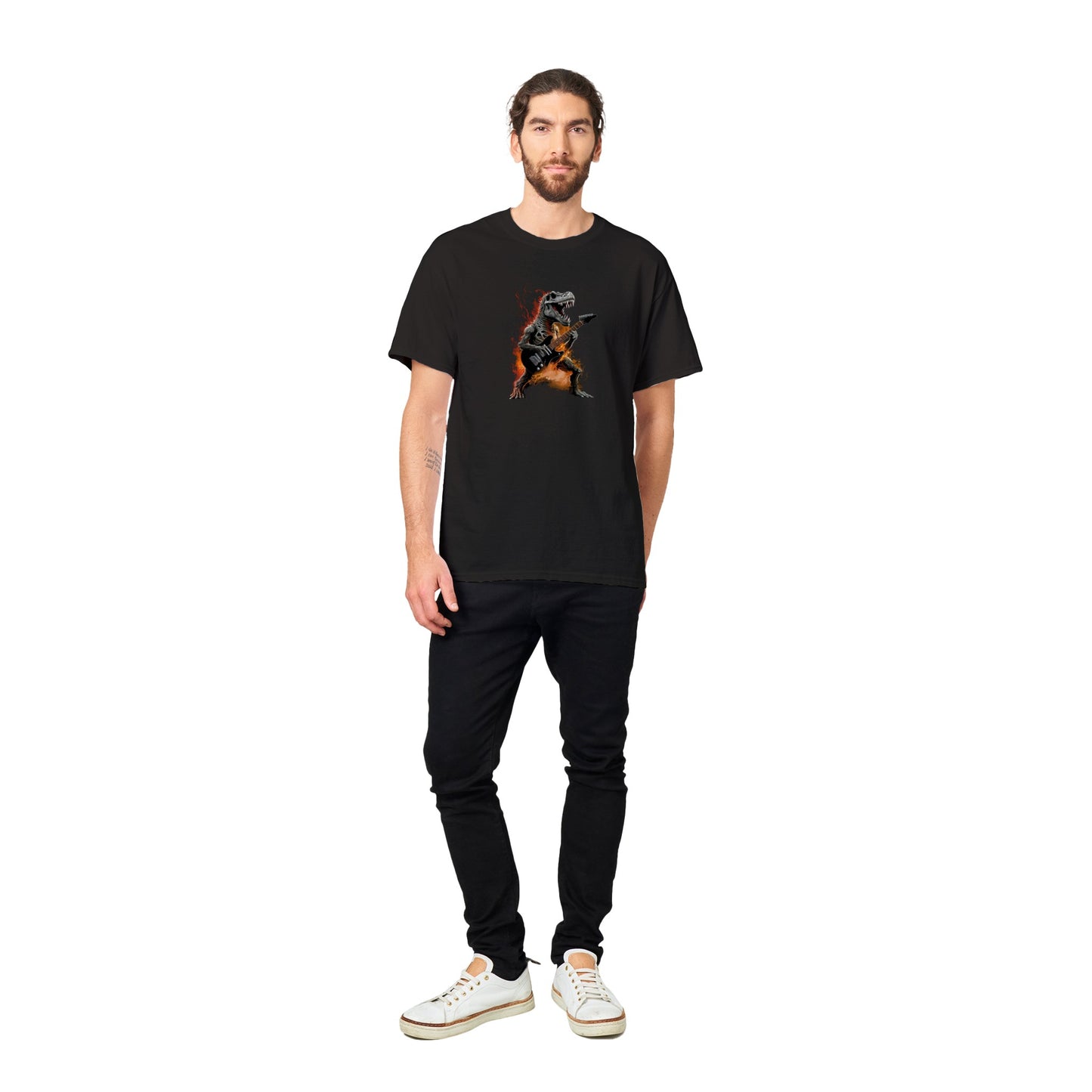 Man sitting on the pavement wearing a black t-shirt with a flaming t-rex playing the guitar graphic