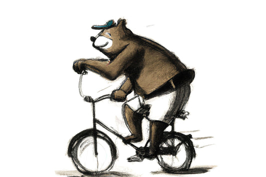 A bear wearing shorts and a cap riding a bike