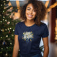 woman standing in front of christmas tree wearing a navy blue t-shirt with a christmas lilies print