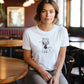 woman in a cafe wearing a white t-shirt with a cute singing fox print