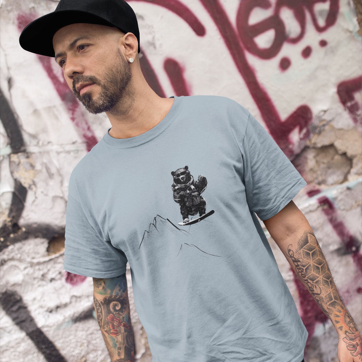 Guy wearing a light blue t-shirt with a snowboarding bear print