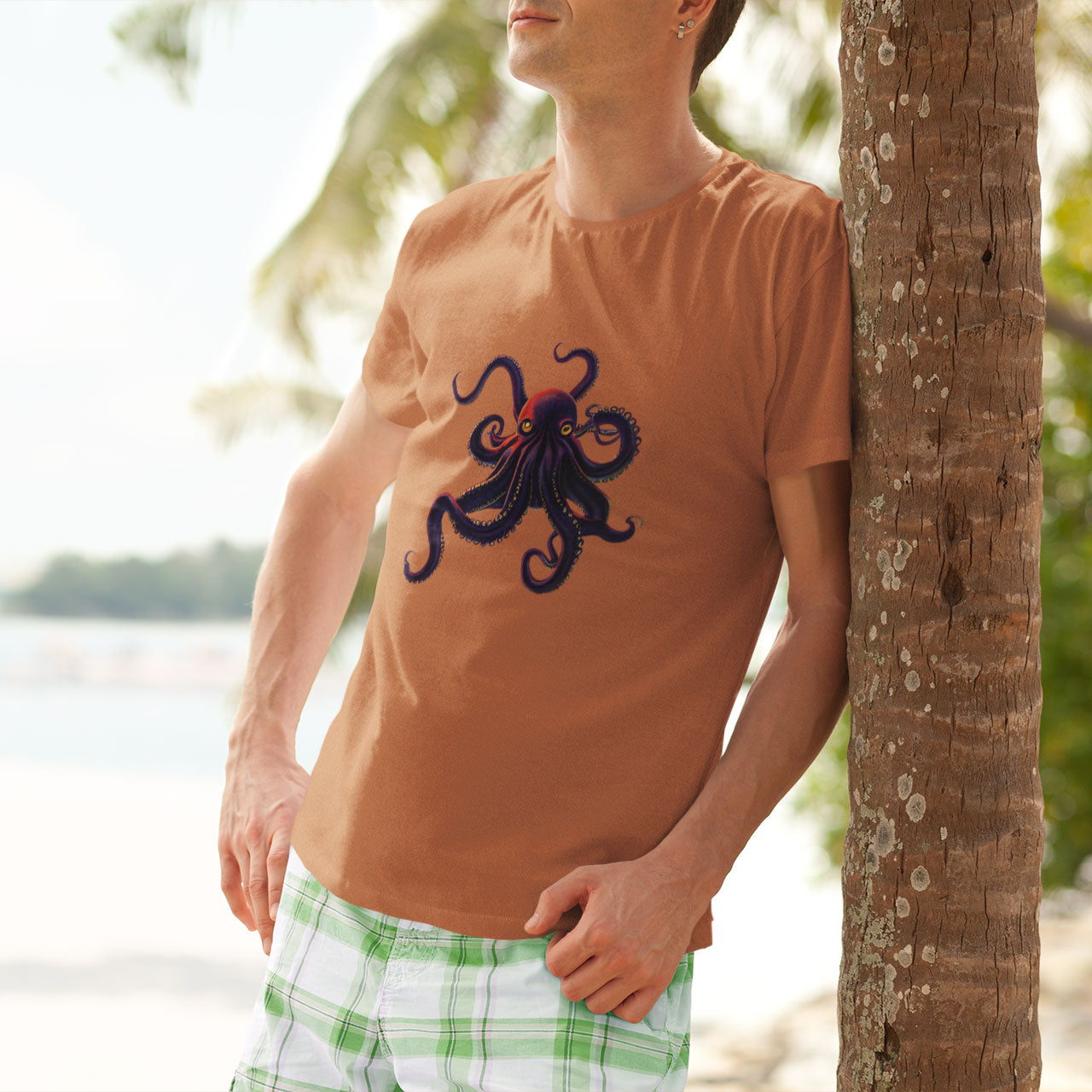Guy leaning on a tree wearing an orange t-shirt with an octopus print