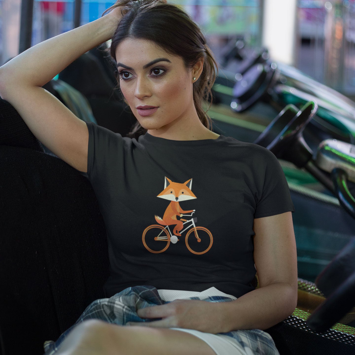 Girl wearing a black t-shirt with a print of a cute fox riding a bike