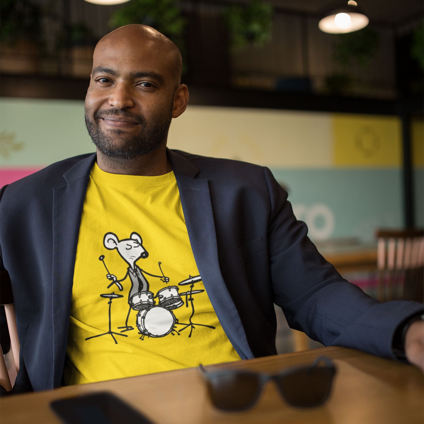 guy wearing a blazer and yellow t-shirt with a mouse playing drums print