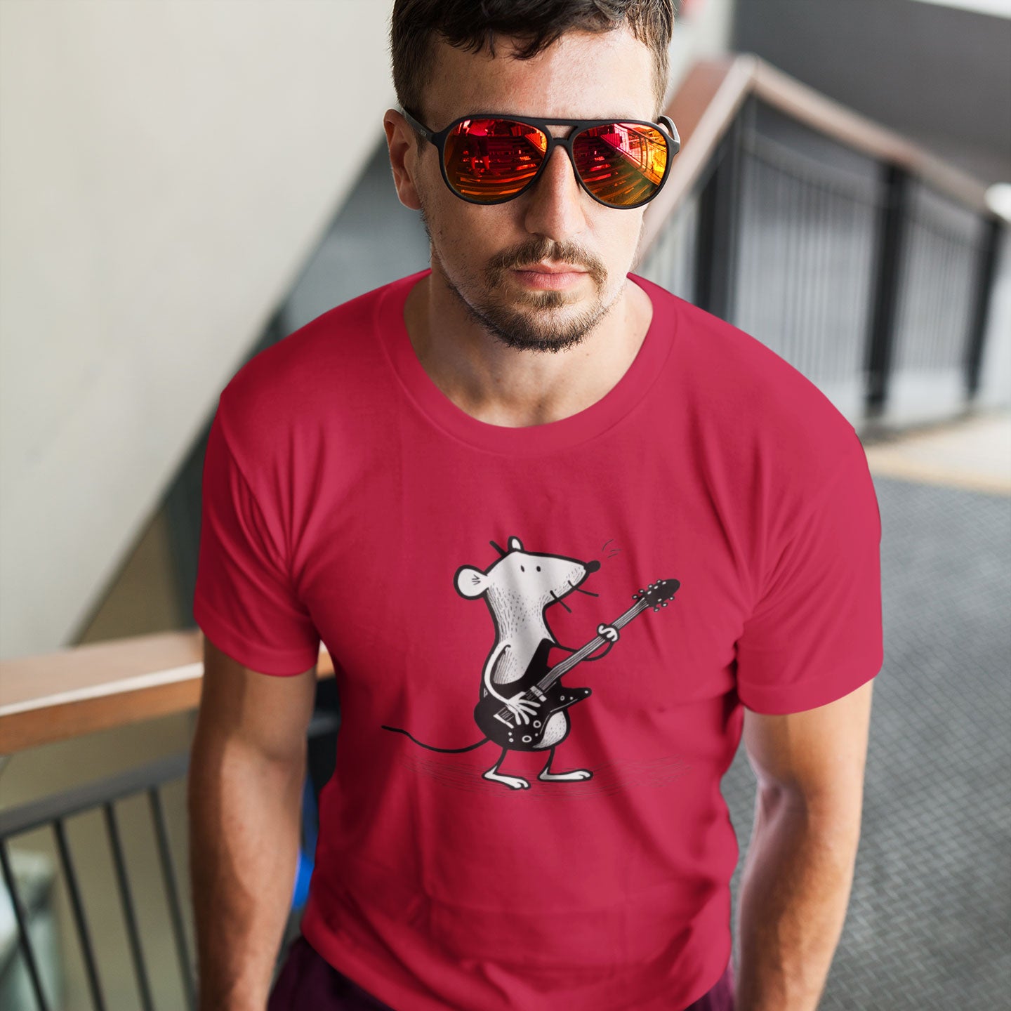 Guy wearing a red t-shirt with a mouse playing guitar print