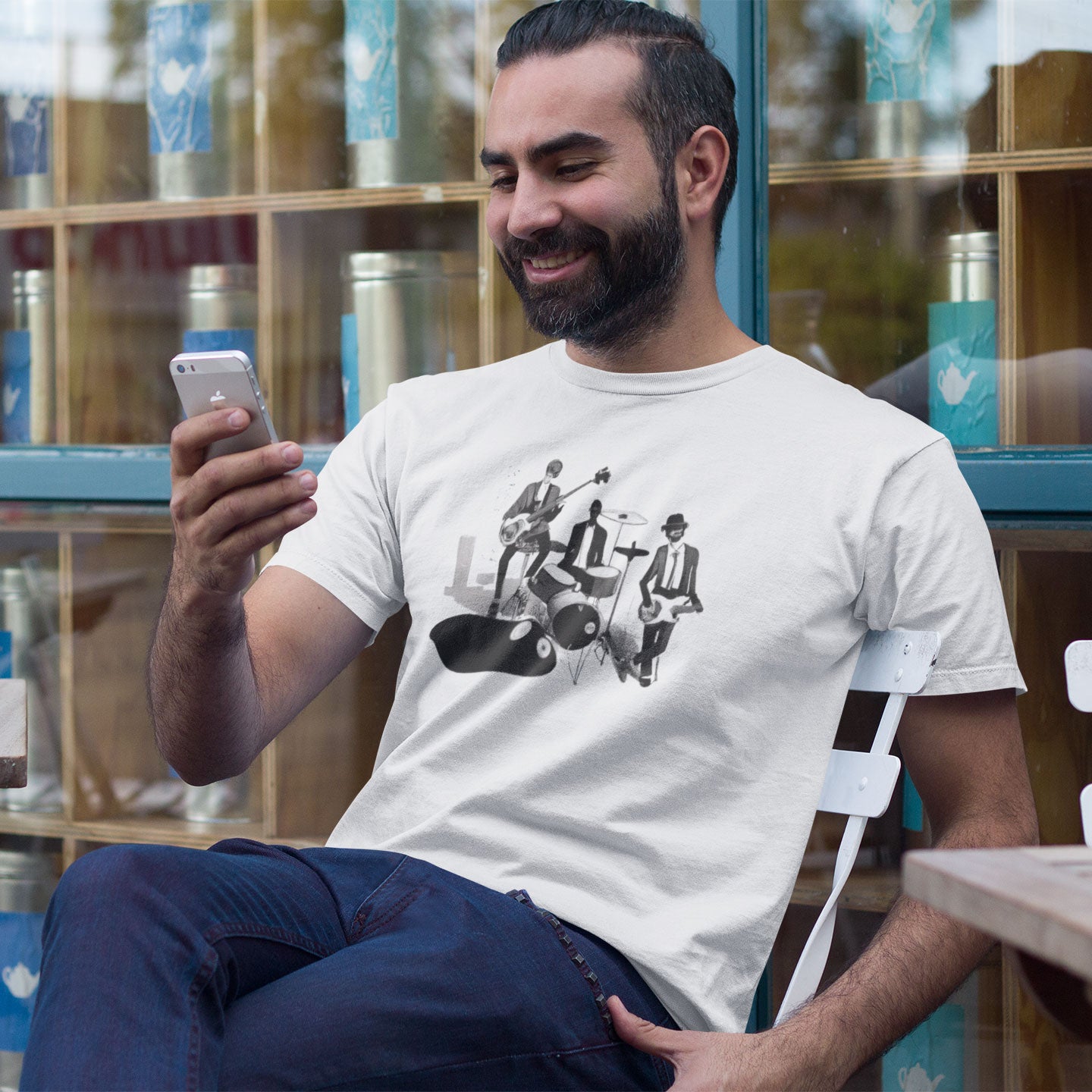 a man looking at his iphone wearing a white t-shirt with a jazz trio print