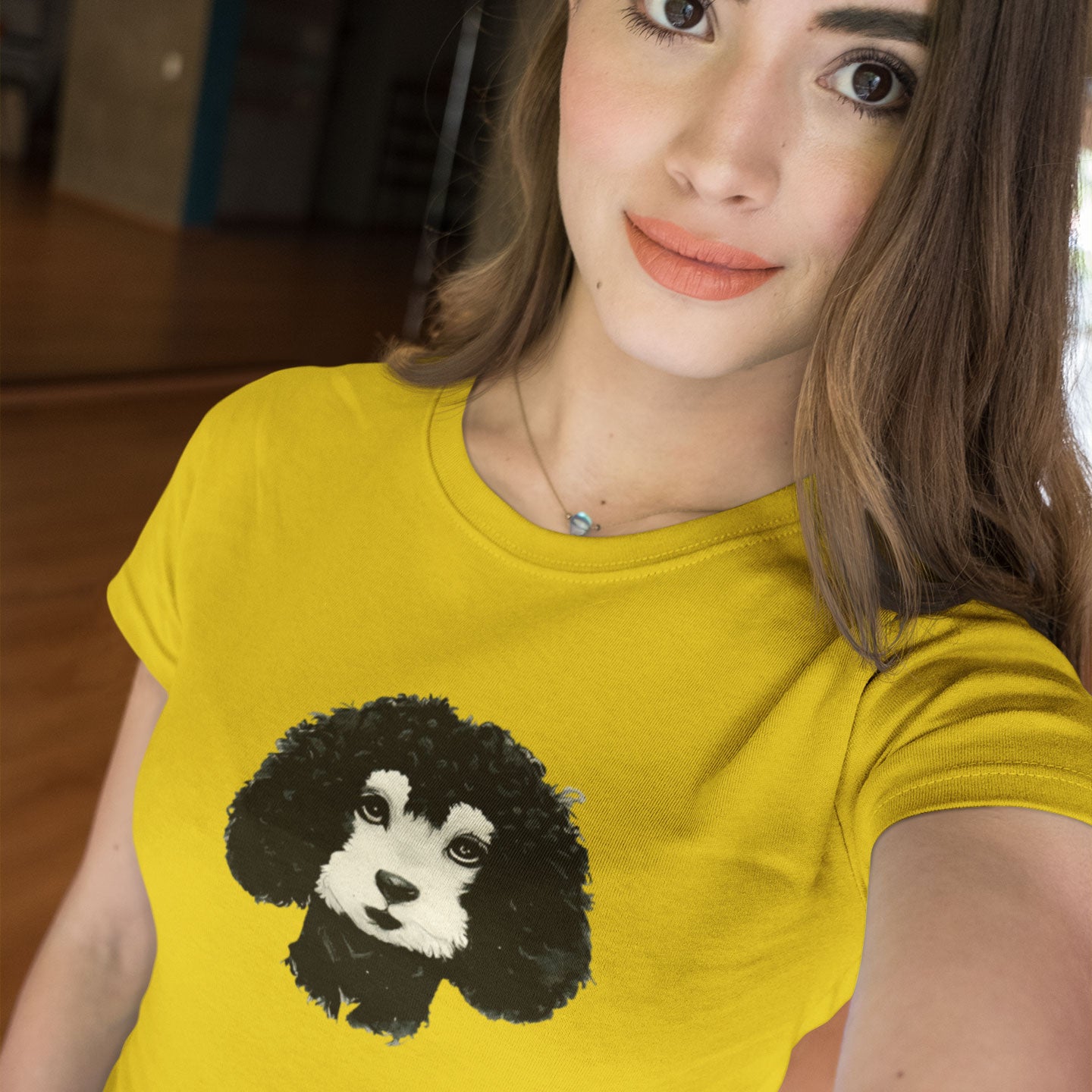 Young woman wearing a gold t-shirt with a black & white poodle print