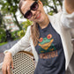 Girl in sunglasses wearing a dark grey t-shirt with a cute frog print with the caption Unfrogettable