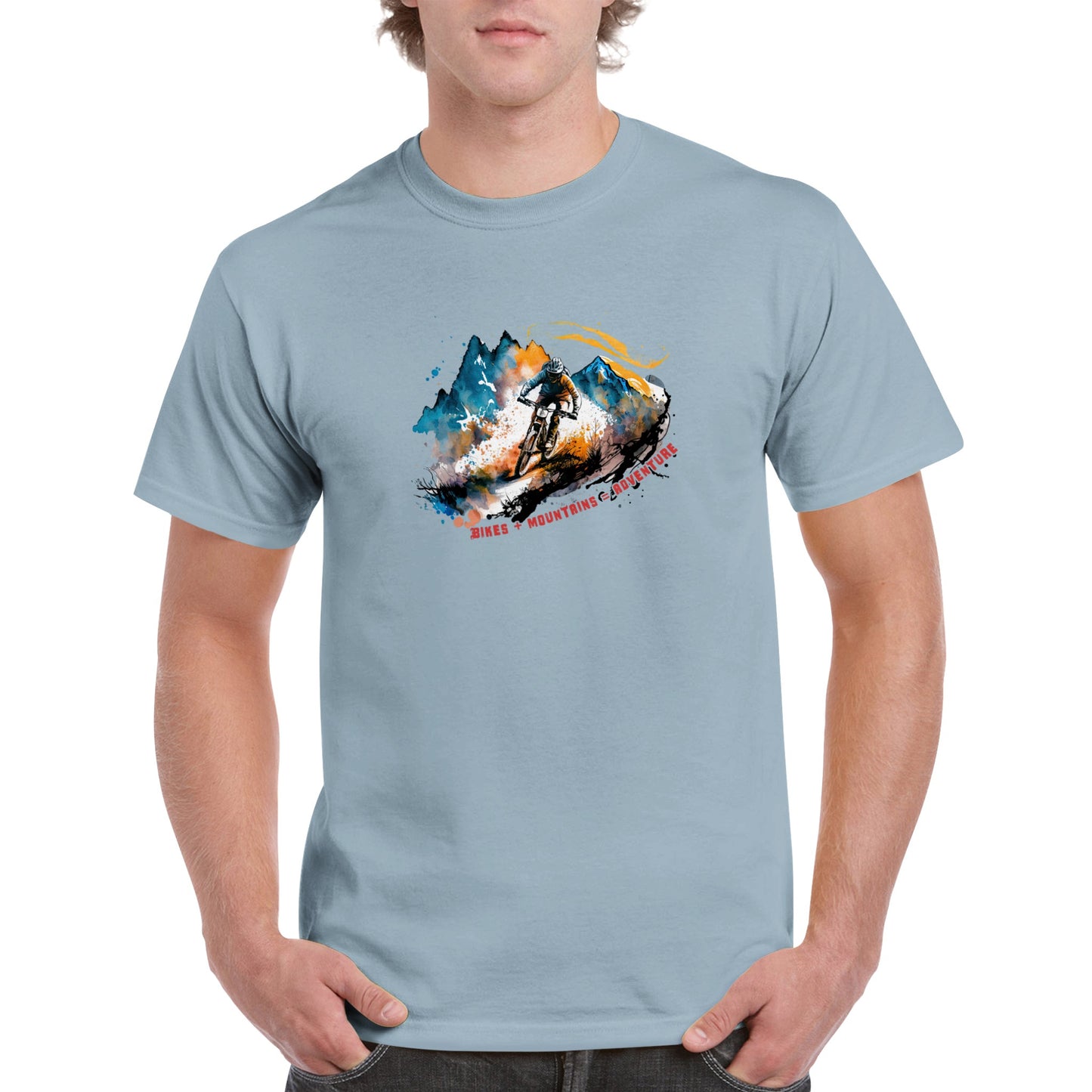 guy wearing a light blue t-shirt with a mountain bike print with the caption Bikes + Mountains = Adventure