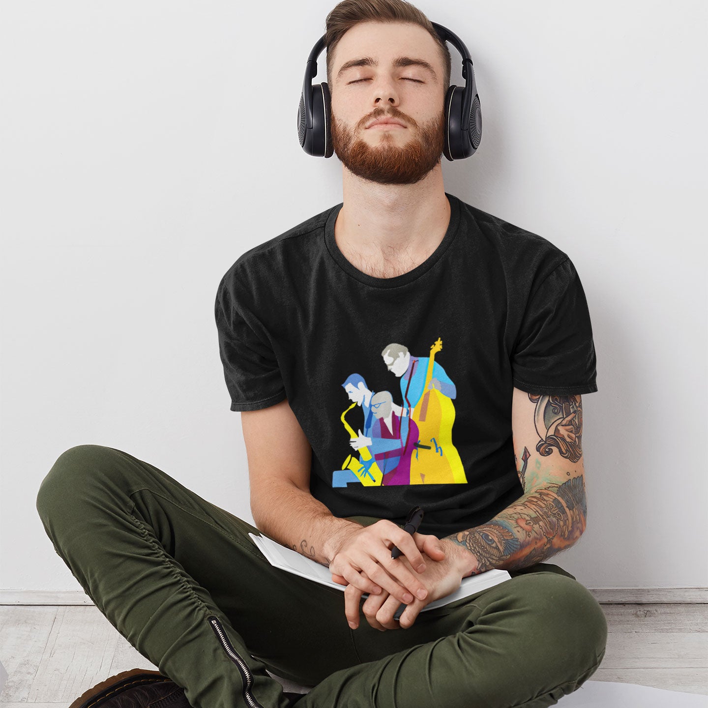 a guy listening to music wearing a black t-shirt with a jazz trio print